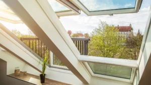Helles Wohnzimmer in der Ferienwohnung mit großem Panoramafenster, das einen beeindruckenden Blick auf das Schloss bietet.