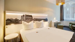 Modernes Bett mit Panoramabild vom Schloss und indirekter Beleuchtung, die bequem vom Bett aus gesteuert werden kann.
