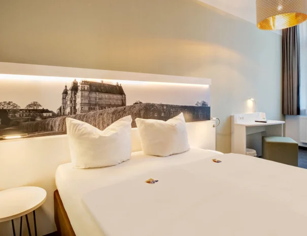 Modernes Bett mit Panoramabild vom Schloss und indirekter Beleuchtung, die bequem vom Bett aus gesteuert werden kann.