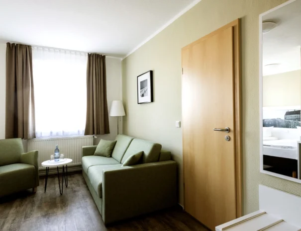 Twin-Bett-Zimmer mit Sitzecke bestehend aus einem Sofa und Sesseln, ideal für Komfort und Entspannung im Hotel Schlosspark.