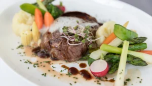 Gegrilltes Entrecôte mit buntem Marktgemüse im Restaurant Wallenstein mit Blick auf das Güstrower Schloss