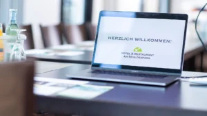 Seminarraum mit Schreibmaterial, Laptop, Wasser und Gläsern im Hotel am Schlosspark Güstrow