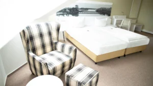 Komfort-Zimmer mit Doppelbett und Lesesessel im Hotel am Schlosspark in Güstrow