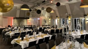 Festlich gedeckte Tische im Heizhaus mit eleganter Dekoration, stilvollen Blumenarrangements und warmem Kerzenlicht.