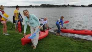 Menschen mit Kajaks am Inselsee bei Güstrow genießen das gemeinsam aktiv gestaltete Bootserlebnis in idyllischer Umgebung.