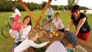 Ein Picknick mit Freunden und Familie am Ufer des Inselsees in Güstrow mit Blick auf das Wasser und die umgebende Natur.