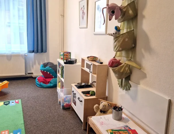 Spielzimmer mit Fernseher, Spielbereich und Sitzmöglichkeiten für Kinder im Hotel am Schlosspark